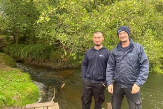 Ben (left) and Darren (right) from the Rivers Team standing in front of a river