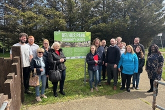 Impulse Leisure staff, volunteers and Team Wilder from Essex Wildlife Trust stand beside new sign for community garden