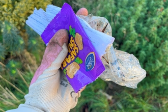 Gloved hand holding multiple pieces of plastic litter