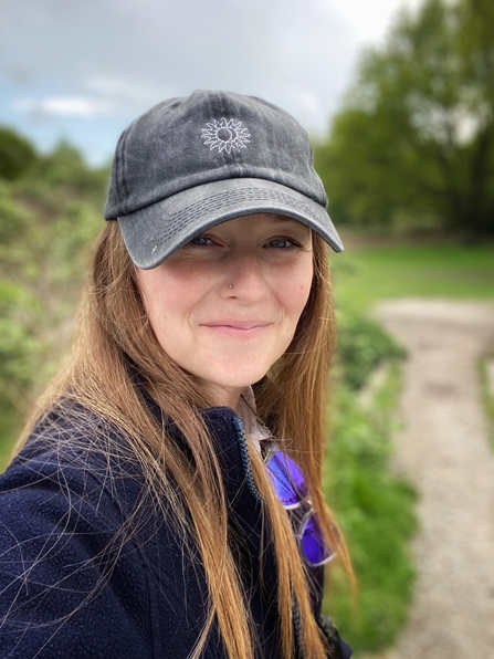 Selfie photo of Eve Ingram wearing a hat at a nature reserve