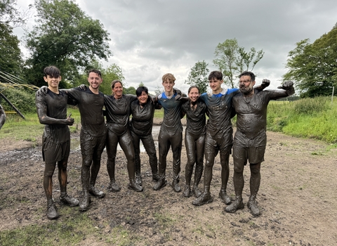 Carbon Numbers corporate group covered in mud after taking part in Running Wild